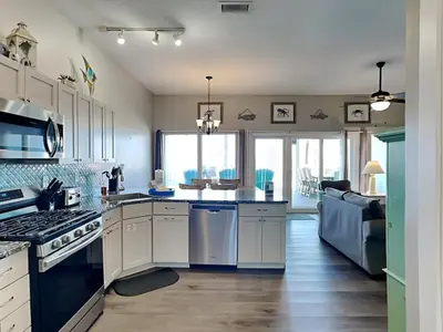 a kitchen with white cabinets and a counter top at Charline Beachside Villa in Panama City Beach