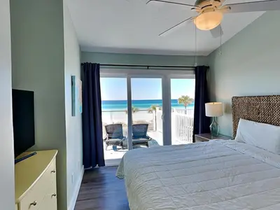 a bedroom with a bed and a view of the ocean at Charline Beachside Villa in Panama City Beach