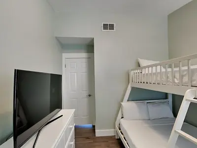 a small bedroom with a bunk bed and a ladder at Charline Beachside Villa in Panama City Beach