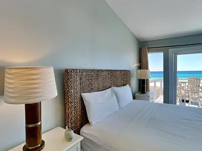 a bedroom with a bed with a view of the ocean at Charline Beachside Villa in Panama City Beach