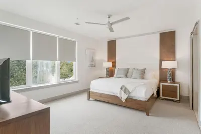 a white bedroom with a bed and two windows at The Pointe Unit 326 by 30A Escapes in Rosemary Beach