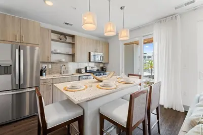 a kitchen with a large island with chairs around it at Texas Two Step by 30A Escapes in Rosemary Beach