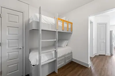 a bedroom with a bunk bed with white walls at Texas Two Step by 30A Escapes in Rosemary Beach