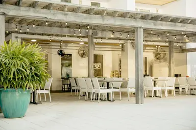a dining room with white chairs and a table at The Pointe Unit 342 by 30A Escapes in Rosemary Beach