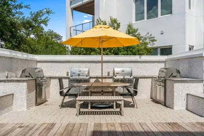 a wooden table with an umbrella on a patio at The Pointe Unit 342 by 30A Escapes in Rosemary Beach