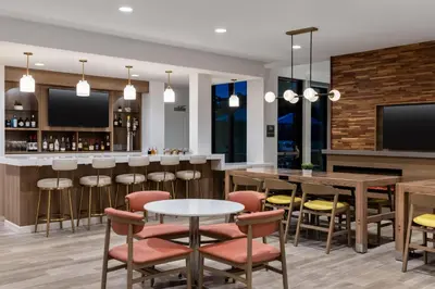 a bar with tables and chairs and a tv at Residence Inn Panama City Beach Pier Park in Panama City Beach