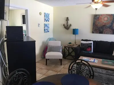 a living room with a couch and a table at Beach Place Seconds to Beach 23 in Panama City Beach