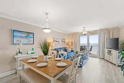 a dining room and living room with a dining table at Emerald Beach #1236 by Book That Condo in Panama City Beach