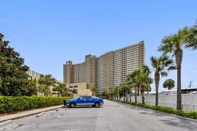 a blue car parked in a parking lot in front of a large building at Emerald Beach #1236 by Book That Condo in Panama City Beach