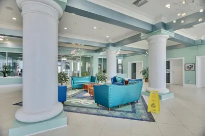 a lobby with blue chairs and columns in a building at Boardwalk Beach Resort #1206 by Book That Condo in Panama City Beach