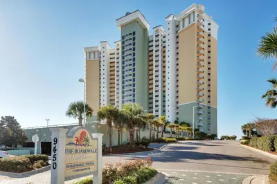 a street in front of a building with palm trees at Boardwalk 2005 in Panama City Beach