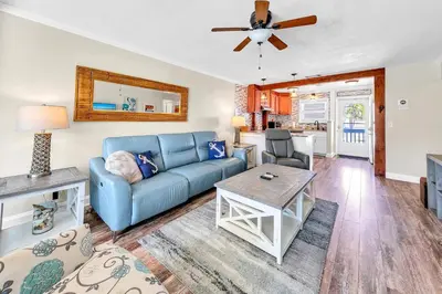 a living room with a blue couch and a table at Misty Harbour 7 in Panama City Beach