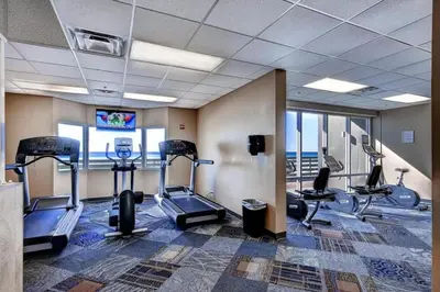 a gym with treadmills and ellipticals in a building at Tidewater 100 in Panama City Beach