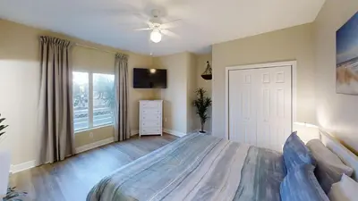 a bedroom with a bed and a ceiling fan at Tidewater 100 in Panama City Beach