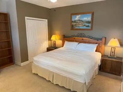 a bedroom with a large white bed with two lamps at Tidewater 100 in Panama City Beach
