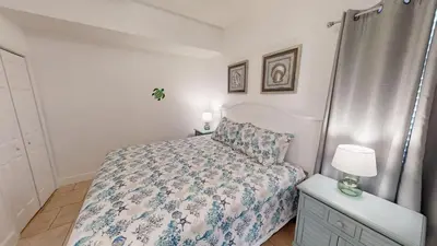 a bedroom with a bed and a lamp on a dresser at Tidewater 2714 in Panama City Beach