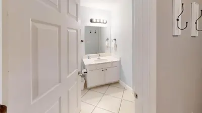 a white bathroom with a sink and a mirror at Tidewater 2714 in Panama City Beach