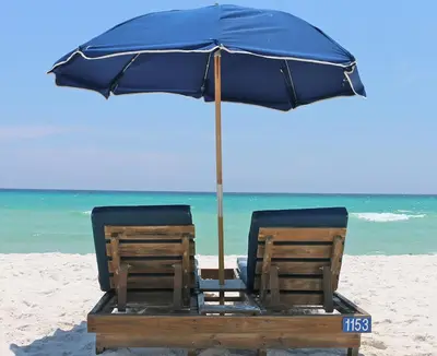two chairs under an umbrella on the beach at Tidewater 2714 in Panama City Beach