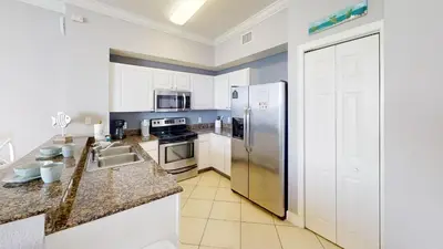 a kitchen with a stainless steel refrigerator and appliances at Tidewater 2714 in Panama City Beach