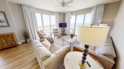 a living room with a couch and a table at Sunrise Beach 1001 in Panama City Beach