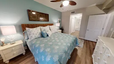 a bedroom with a bed with a blue comforter at Sunrise Beach 1001 in Panama City Beach