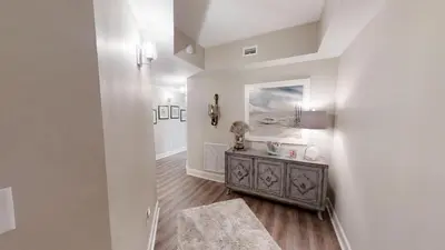a living room with a table and a mirror at Sunrise Beach 1001 in Panama City Beach