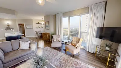 a living room with a couch and a large window at Sunrise Beach 1001 in Panama City Beach