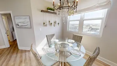 a dining room with a glass table and chairs at Sunrise Beach 1001 in Panama City Beach