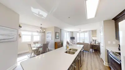 a kitchen and living room with a sink and a table at Sunrise Beach 1001 in Panama City Beach