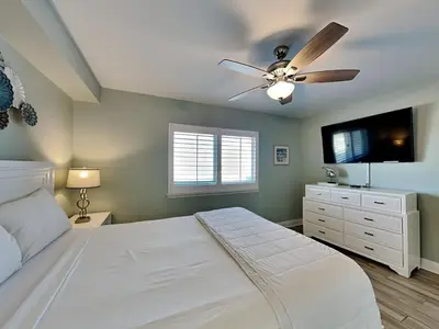 a bedroom with a white bed and a ceiling fan at Emerald Beach #830 in Panama City Beach