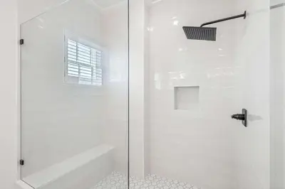 a white bathroom with a shower with a glass door at 30A Sunset in Santa Rosa Beach