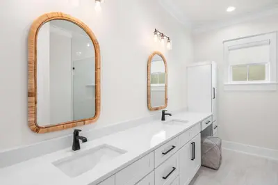a bathroom with two sinks and two mirrors at 30A Sunset in Santa Rosa Beach