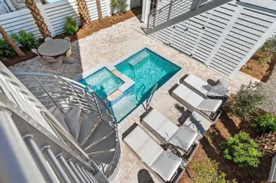 an overhead view of a swimming pool with chairs and a table at 30A Sunrise in Santa Rosa Beach