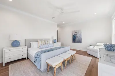 a white bedroom with a bed and a couch at 30A Sunrise in Santa Rosa Beach