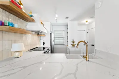 a kitchen with a white counter top and a sink at Howdy Beach by 30A Escapes in Panama City Beach