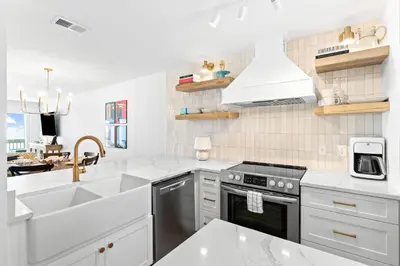 a white kitchen with a sink and a stove at Howdy Beach by 30A Escapes in Panama City Beach