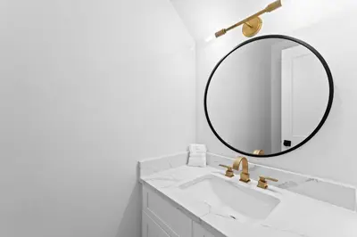 a bathroom with a white sink and a mirror at Howdy Beach by 30A Escapes in Panama City Beach