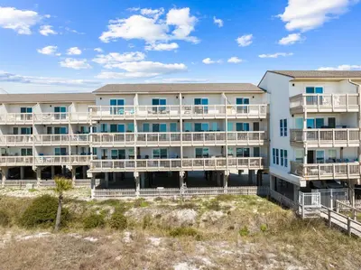 an exterior view of a large apartment building with balconies at Howdy Beach by 30A Escapes in Panama City Beach