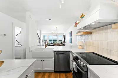 a white kitchen with a sink and a dishwasher at Howdy Beach by 30A Escapes in Panama City Beach