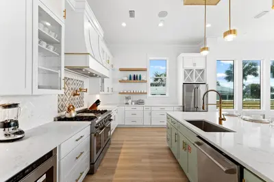 a white kitchen with white cabinets and a counter top at Jewel of Oleander by 30A Escapes in Panama City Beach