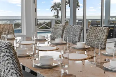 a table with chairs and plates and cups on it at Jewel of Oleander by 30A Escapes in Panama City Beach