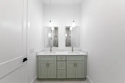a bathroom with a green sink and two mirrors at Jewel of Oleander by 30A Escapes in Panama City Beach