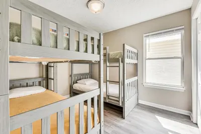 a room with two bunk beds and a window at Charming PCB Home about 1 Mi to Beach Access! in Panama City Beach