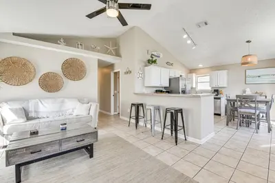 a living room and kitchen with a couch and a table at Charming PCB Home about 1 Mi to Beach Access! in Panama City Beach