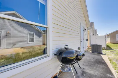 a grill sitting on a stand next to a house at Charming PCB Home about 1 Mi to Beach Access! in Panama City Beach