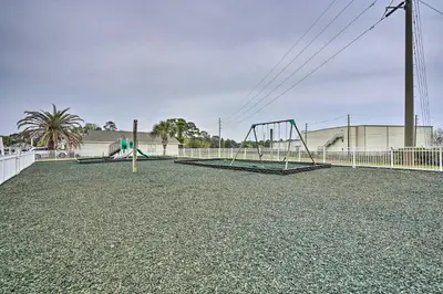 a playground with two swings and a slide at Charming PCB Home about 1 Mi to Beach Access! in Panama City Beach