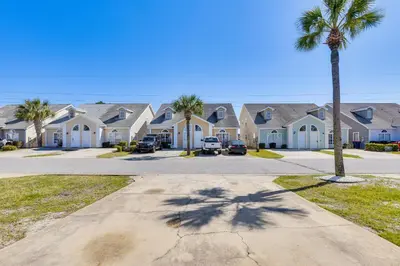 a row of houses with palm trees in a street at Charming PCB Home about 1 Mi to Beach Access! in Panama City Beach