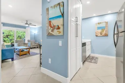 a kitchen and living room with blue walls at Somewhere in the Sun in Santa Rosa Beach