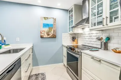 a kitchen with white cabinets and a sink at Somewhere in the Sun in Santa Rosa Beach