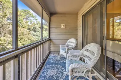a porch with two chairs and a rug at Somewhere in the Sun in Santa Rosa Beach